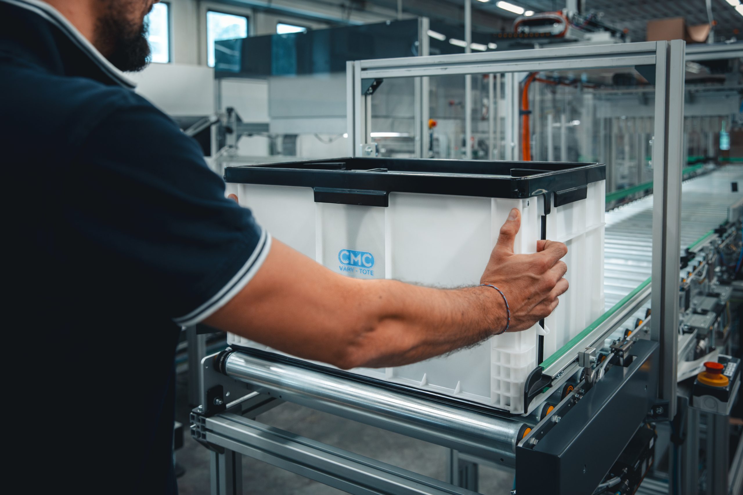 Operator positioning a CMC Vary-Tote on an automated fulfilment conveyor